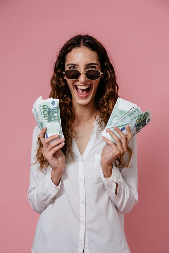 woman in white button up shirt holding money