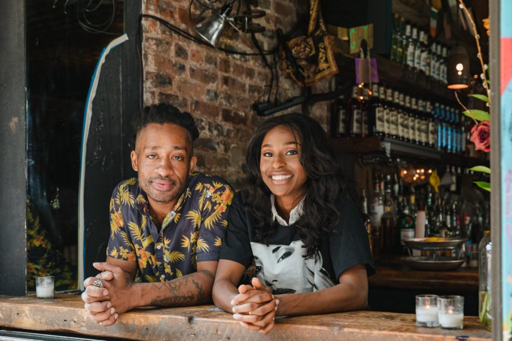portrait of smiling owners at cafe window